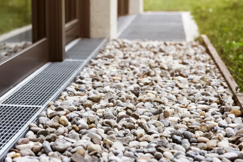 French drain installation with gravel-filled drainage trench