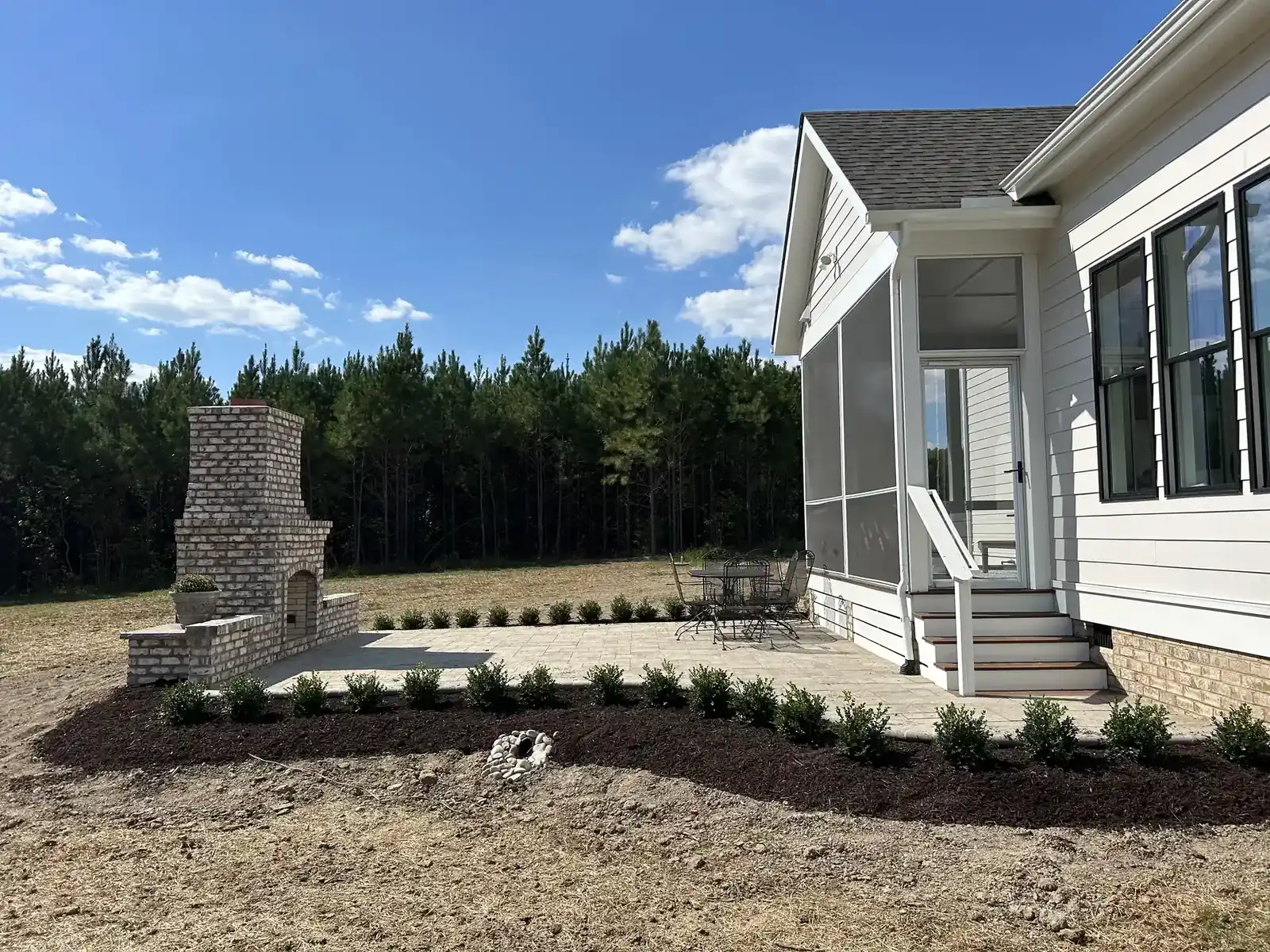 Custom paver patio and outdoor fireplace hardscape installation — hardscaping services in Charlottesville, VA