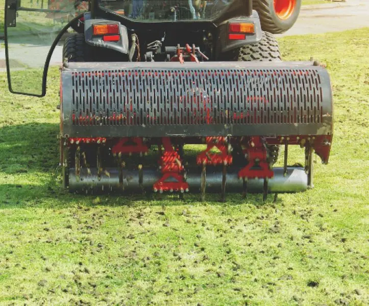 Core aerator machine in action on a residential lawn — lawn aeration services in Charlottesville, VA